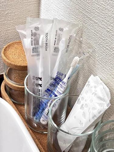 a counter with toothbrushes and toothpaste in plastic bags at Osaka Rejoice ST'A'Y-KUROSAKI in Osaka