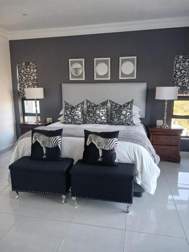 a bedroom with a large bed with two zebra pillows at La Chambre Manor House in Nelspruit