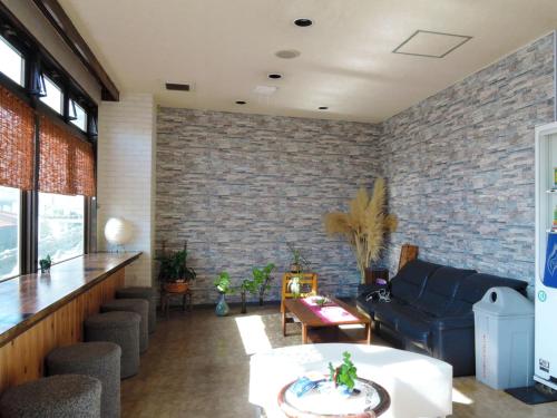 a living room with a couch and a brick wall at Ichifukuso in Tara