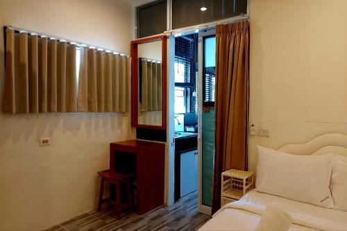 a bedroom with a bed and a mirror and a window at Suanmali Samui in Lamai