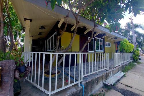a yellow house with a white fence in front of it at Suanmali Samui in Lamai
