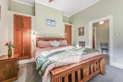 a bedroom with a large bed with a wooden headboard at Fantail House Kaiuma Bay - Havelock Holiday Home in Havelock
