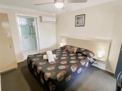 a bedroom with a large bed and a bathroom at High Street Motor Inn in Stanthorpe