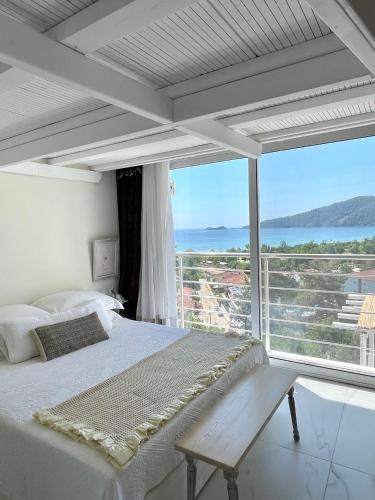 a bedroom with a bed and a large window at Mare Monte Small Boutique Hotel in Chrysi Ammoudia