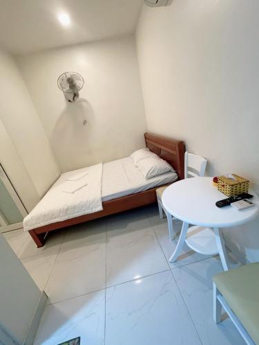 a small room with a bed and a table at Nguyên Thanh Hotel in Ho Chi Minh City