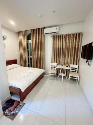 a bedroom with a bed and a table and chairs at Nguyên Thanh Hotel in Ho Chi Minh City