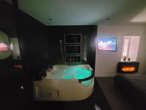 La salle de bains est pourvue d'une baignoire dans une chambre sombre. dans l'établissement Love-house, à Bouleternère