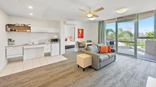 a kitchen and living room with a couch and a table at Hotel Diana South Brisbane in Brisbane