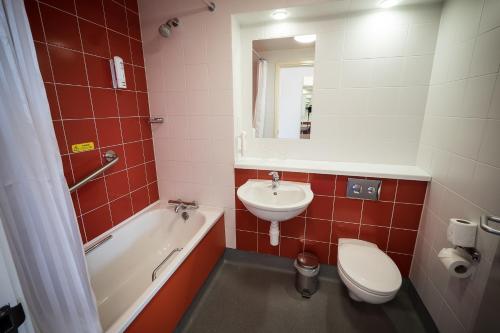W łazience znajduje się umywalka, toaleta i wanna. w obiekcie Travelodge Limerick Castletroy w mieście Limerick