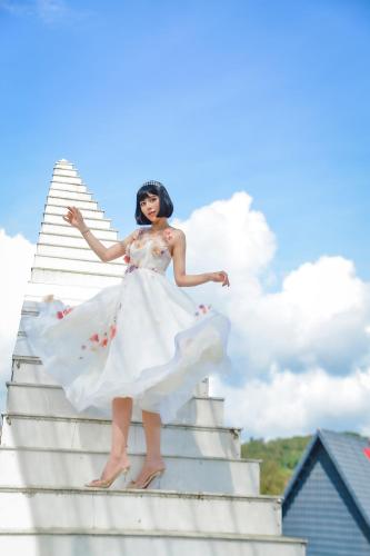 a woman in a white dress standing on some stairs at Resort Hàng Dương in Blao Klong Ner