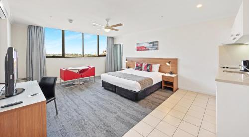 a hotel room with a bed and a desk at Hotel Diana South Brisbane in Brisbane