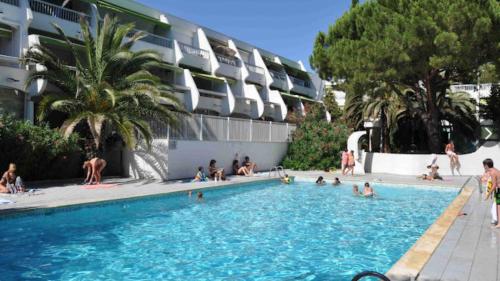 un groupe de personnes assises dans une piscine dans l'établissement Horizon Piscine, Clim WIFI Parking Cosy 3min de l'étang top prosConciergerie, à La Grande Motte