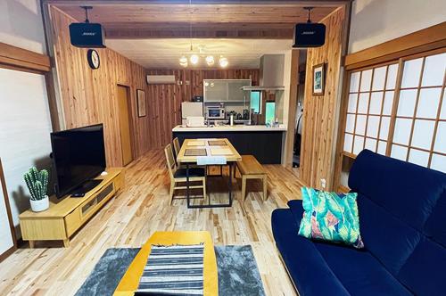 Una sala de estar con un sofá azul y una mesa. en Five Tree House -九十九里 香取, 海も山も大満喫できるコテージ-, en Katori