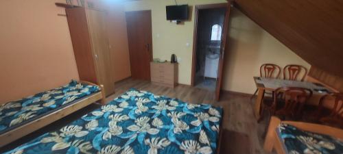 a bedroom with a bed and a table and a dining room at Kwatera u Stasia i Małgosi in Korbielów