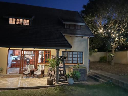 a house with a porch with chairs and a table at OAK HOUSE, Entire holiday home, Self catering, fully equipped, double storey, 3 bedroom, 2 bathroom, outside entertainment, Braai area, 300sqm home in Hillcrest