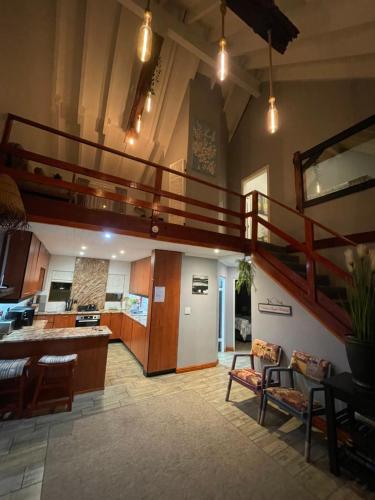 a large living room with a staircase and a kitchen at OAK HOUSE, Entire holiday home, Self catering, fully equipped, double storey, 3 bedroom, 2 bathroom, outside entertainment, Braai area, 300sqm home in Hillcrest