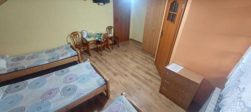 a room with two bunk beds and a table and chairs at Kwatera u Stasia i Małgosi in Korbielów