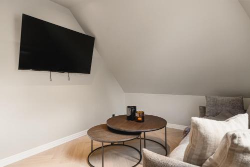 a living room with a table and a tv at Bryggen // Fløyen Living in Bergen