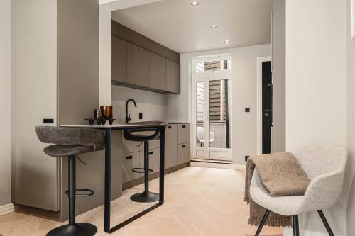 a kitchen with a counter and two bar stools at Bryggen // Fløyen Living in Bergen