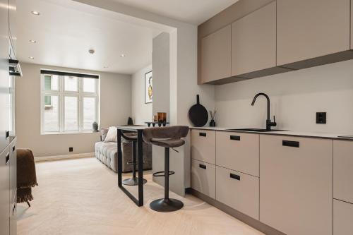 a kitchen with white cabinets and a table and a couch at Bryggen // Fløyen Living in Bergen