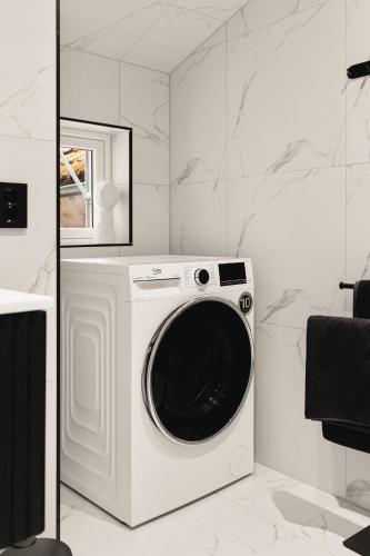 a white washing machine in a white room at Bryggen // Fløyen Living in Bergen