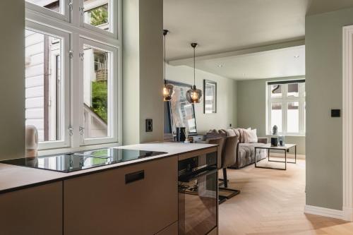 a kitchen with a counter and a living room at Bryggen // Fløyen Living in Bergen