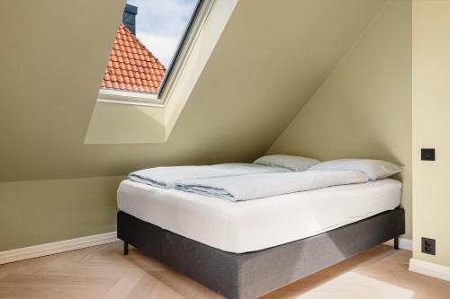 a bed in a room with a window at Bryggen // Fløyen Living in Bergen