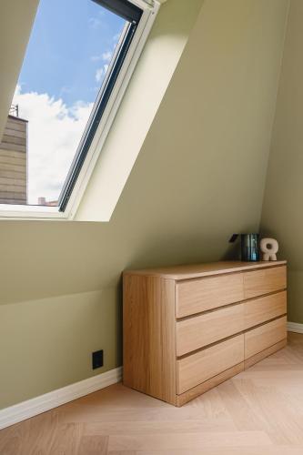 a room with a wooden dresser and a window at Bryggen // Fløyen Living in Bergen