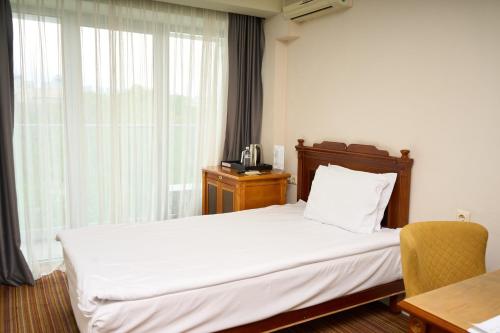 a hotel room with a bed and a window at Almaty Hotel in Almaty