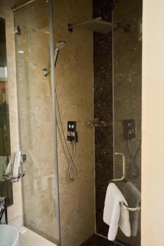 a shower with a glass door in a bathroom at Almaty Hotel in Almaty