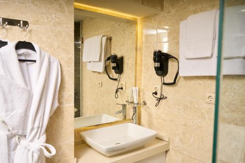 a bathroom with a sink and a mirror at Almaty Hotel in Almaty
