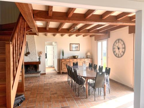 une salle à manger avec une table et des chaises dans l'établissement La Maison de L'Hermitage 225 m2 terrain 2300 m2, à Planguenoual