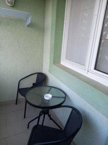 a table and two chairs and a table and a window at Valéria Vendégház Hévíz in Hévíz