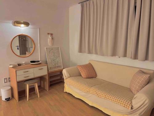 a living room with a couch and a mirror at Juns House 대인원 수용 가능, 2층 복층 주택, 테라스보유, 가족숙소 적합 in Pohang