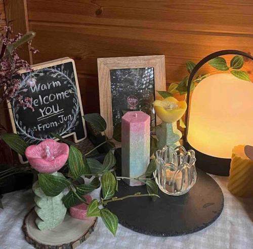 a table with a candle and a mirror and flowers at Juns House 대인원 수용 가능, 2층 복층 주택, 테라스보유, 가족숙소 적합 in Pohang