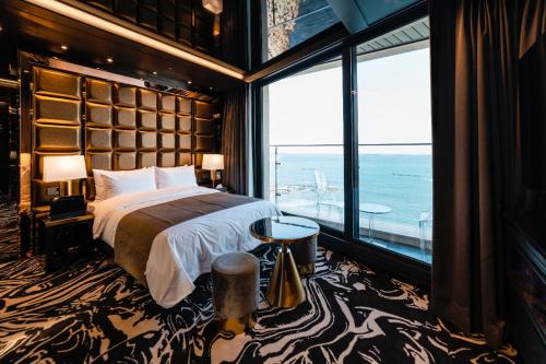 a bedroom with a large bed and a large window at Best Louis Hamilton Hotel Ocean Terrace in Busan
