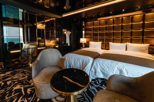 a bedroom with two beds and a table and chairs at Best Louis Hamilton Hotel Ocean Terrace in Busan