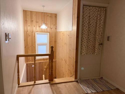 a hallway with a door leading to a room with wooden walls at Juns House 대인원 수용 가능, 2층 복층 주택, 테라스보유, 가족숙소 적합 in Pohang