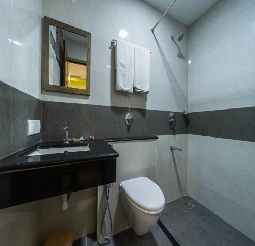 a bathroom with a toilet and a sink and a mirror at SAU Residency in Kanchipuram