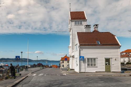 a white building with a red roof on a street at Bryggen // Fløyen Living in Bergen