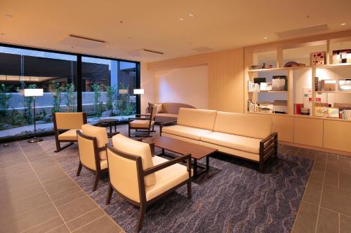 a waiting room with a couch and tables and chairs at Hotel Intergate Kyoto Shijo Shinmachi in Kyoto