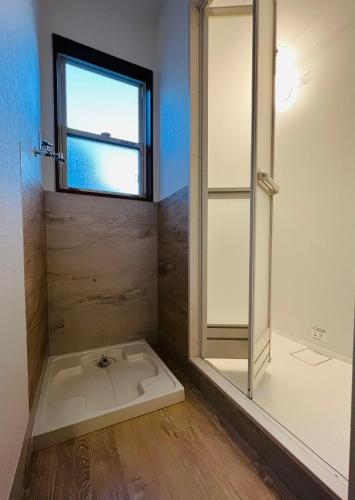 a bathroom with a shower and a window at スペース海浜幕張ハウス in Chiba