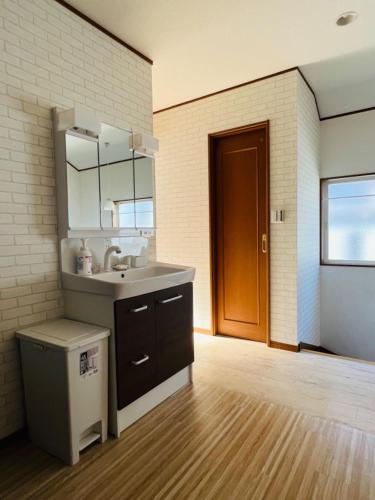 a bathroom with a sink and a mirror at スペース海浜幕張ハウス in Chiba