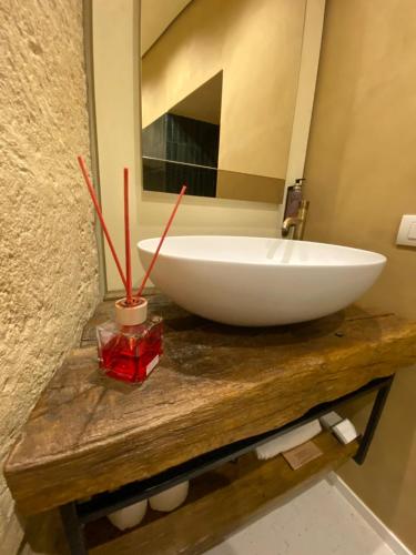 a bathroom with a white bowl sink on a wooden counter at La dimora di Don Antonio in Matera
