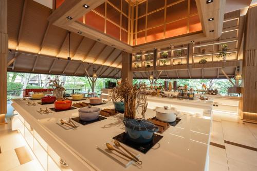 Una habitación grande con una mesa con plantas en macetas. en Villa Zolitude Resort & Spa - SHA Extra Plus, en Chalong 