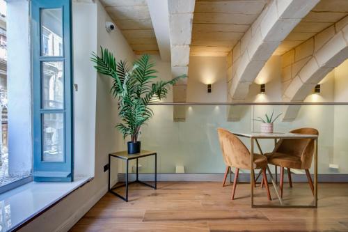 a dining room with a table and chairs and a plant at 23 Boutique Hotel in Il-Furjana