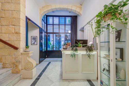 an entrance to a store with potted plants at 23 Boutique Hotel in Il-Furjana