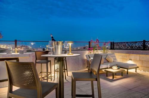 a patio with a table and chairs on a balcony at 23 Boutique Hotel in Il-Furjana