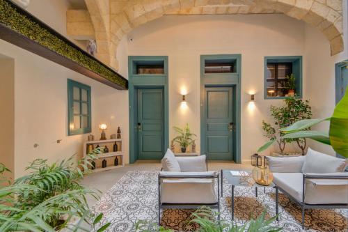 an indoor patio with blue doors and plants at 23 Boutique Hotel in Il-Furjana