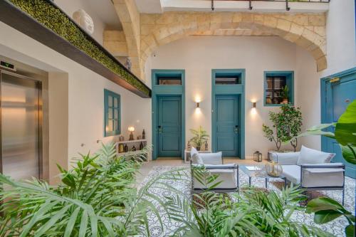 a living room with blue doors and plants at 23 Boutique Hotel in Il-Furjana